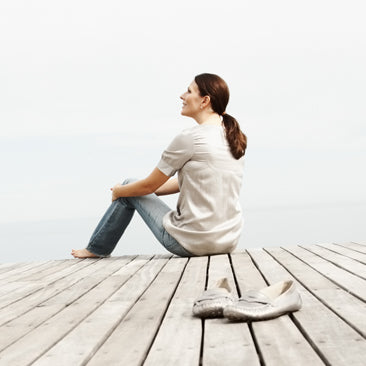 Kvinna sittande utomhus på träbrygga, jurist inom GDPR